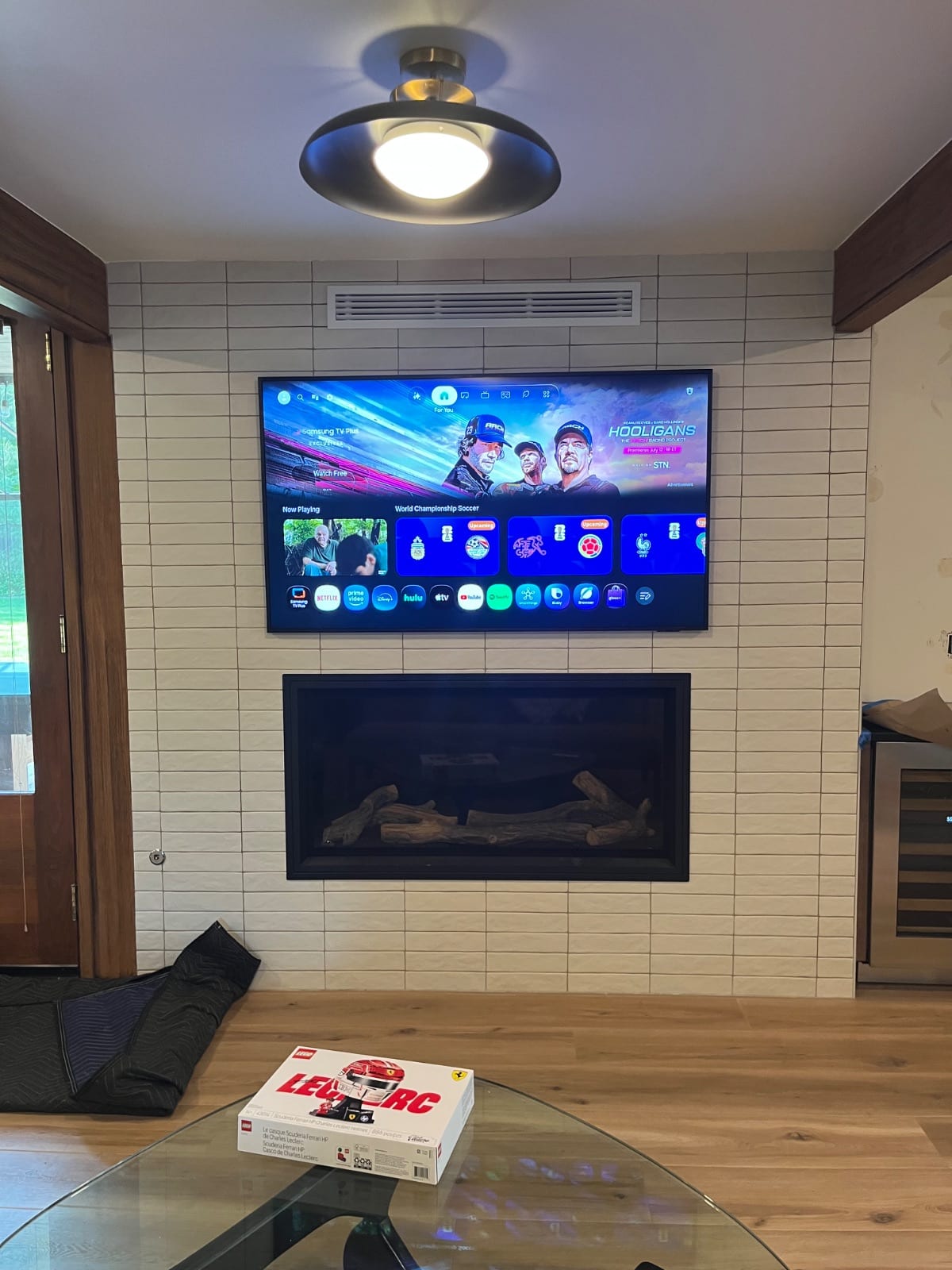 TV mounted on a tiled wall above a fireplace